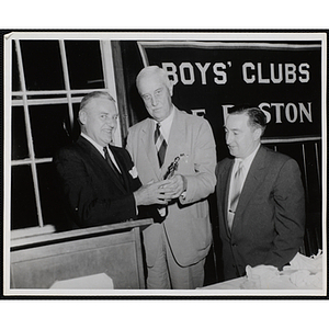 Joseph P. Spang, Jr., at left, holding a trophy with Hon. Leo H. Leary while State Senator John E. Powers looks on at a Boys' Clubs of Boston awards event