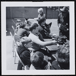 The participants holding their dogs as the judges score them during a Boys' Club Pet Show