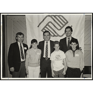 Mayor Raymond L. Flynn, at center, posing with three award recipients and two unidentified men in front of the Boys and Girls Club banner