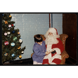 Santa Claus gives a gift to a girl