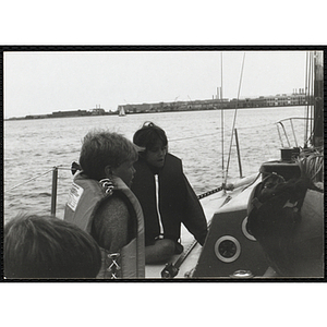 Two children sitting along the port side of a sailboat