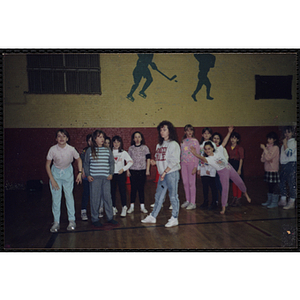 A group of girls form a line against a wall in a gymnasium