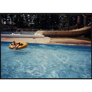 A boy sits in an intertube in a swimming pool at Water Country water park during a Tri-Club field trip