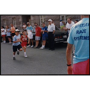 Two boys run past a group of spectators during the Bunker Hill Road Race