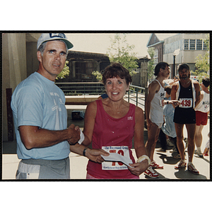 A woman and man shaking hands pose for a shot during the Battle of Bunker Hill Road Race