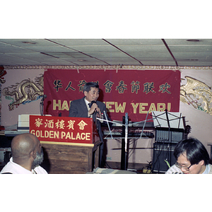 Man speaks to a restaurant full of people gathered to celebrate the Chinese New Year