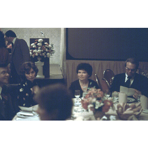 Group of people seated at a dinner table in a banquet hall