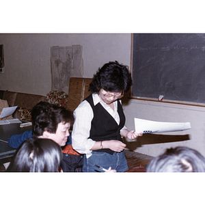 Teacher looks over a student's work in an English class