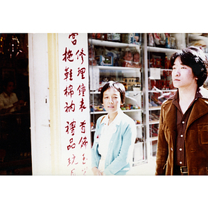 Female Youxie delegate from the U.S.-China Peoples Friendship Association walks with a male member of the Chinese Progressive Association on a street in Boston's Chinatown