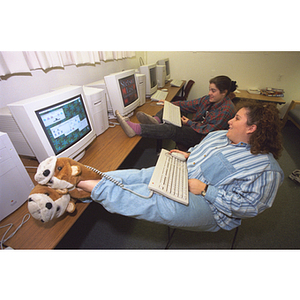 Two female students use computers in a common area of Stetson East