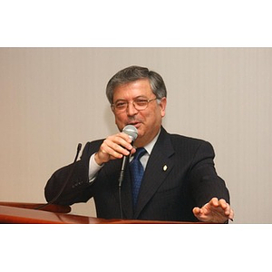 George Chryssis speaks into a microphone at The National Council Dinner