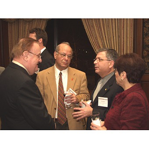 Four attendees stand before gala dinner to honor John Hatsopoulos