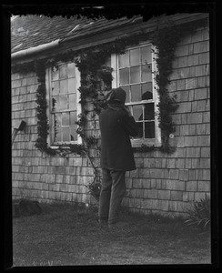Reuben Austin Snow, the cross-dressing hermit of Cape Cod, looking in the cottage window