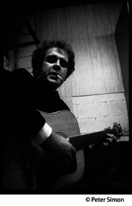 Tim Hardin smoking a cigarette and playing guitar at the Unicorn Coffee House, Boston, Mass.