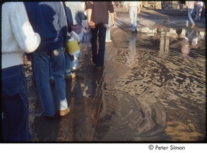 MUSE concert and rally: demonstrators crossing a puddle on wooden boards