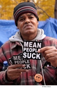 Occupy Wall Street: man holding 'mean people suck' stickers