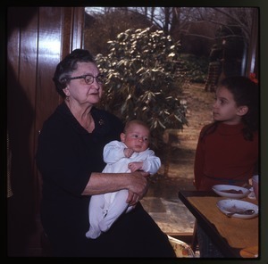 Older woman holding baby (Eben) at table