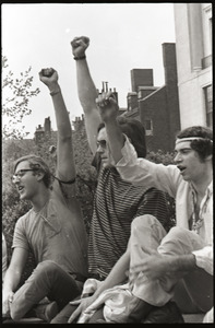 Demonstration at State House against the killings at Kent State: protesters seated on State House, raising fists