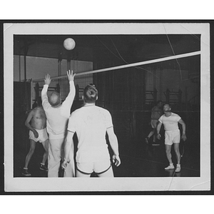 Four men playing volleyball