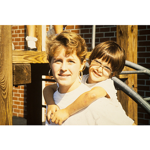 Child riding piggyback on woman's shoulders