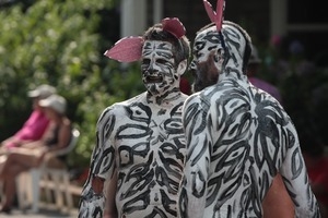 Men decked out in black and white body paint and false pink ears : Provincetown Carnival parade