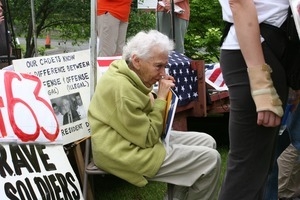 Older woman seated during an anti-Iraq War protest