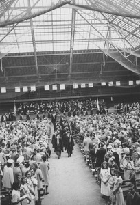 Faculty, dignitaries and speakers walk through Curry Hicks Cage