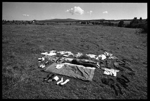 Man lying stretched out with his drying clothes in a field, Earth People's Park