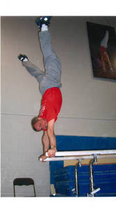 Stephen E. Posner performing handstand on parallel bars, 1999
