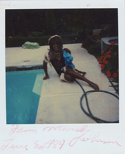 A Photograph of Marsha P. Johnson Sitting on the Ground Next to a Pool, Wearing a Black Dress with Fur Trimming