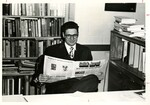 Suffolk University Dean Donald Grunewald (CAS), seated and holding a copy of Suffolk Journal, photograph, circa 1968