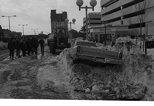 Pedestrians in front of car buried in snow on Cambridge Street