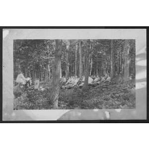 People seated in woods during arts and crafts class