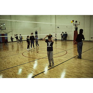 Children and adults gathered on a volleyball court