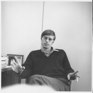 Paul Theroux seated in an office