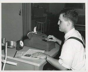 Frank Lettiere using an adding machine as part of a clerical test