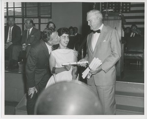 Bruce Barton handing diploma to client while an unidentified man kisses her cheek