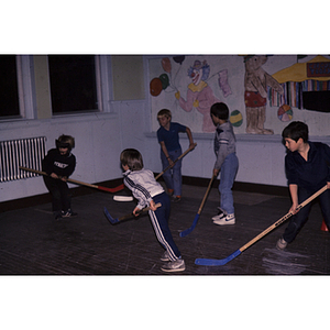 Boys playing hockey indoors