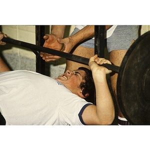 Man struggles to lift a barbell