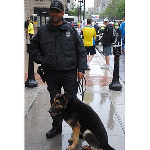 A Boston police officer stands beside his dog at One Run