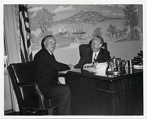 An unidentified man shaking hands with Mayor John F. Collins