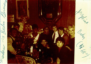 A Photograph of Marlow Monique Dickson in a Group Posing Around a Table