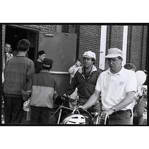 Jerry Steimel, Charlestown Clubhouse director, at far right, and an unidentified man walking with their bicycles at the Boys and Girls Clubs of Boston 100th Anniversary Celebration Street Fair