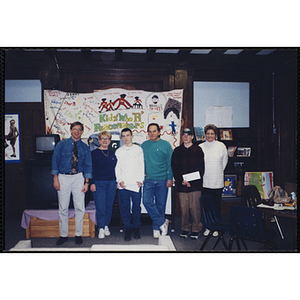 Several adults and youth pose for a group photo during an open house