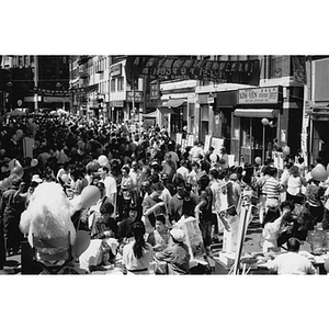 Crowded street in Chinatown during the August Moon Festival, with signs advertising Parcel C