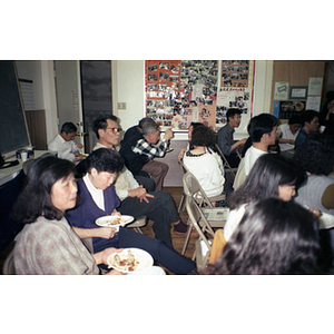 Association members sit and eat dinner while listening to a speaker