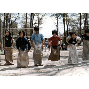 Children compete in a sack race during an Association picnic