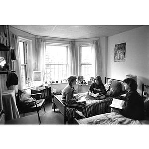 Three female students sit in a dorm room at 119 Hemenway Street