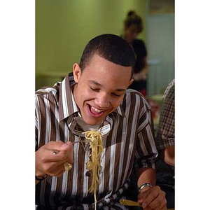 Odalis David Polanco eats pasta when the Torch Scholars visit the Exhibition Kitchen