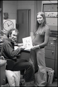 Richard Safft and unidentified woman with copy of Free Spirit Press magazine in radio broadcast studio